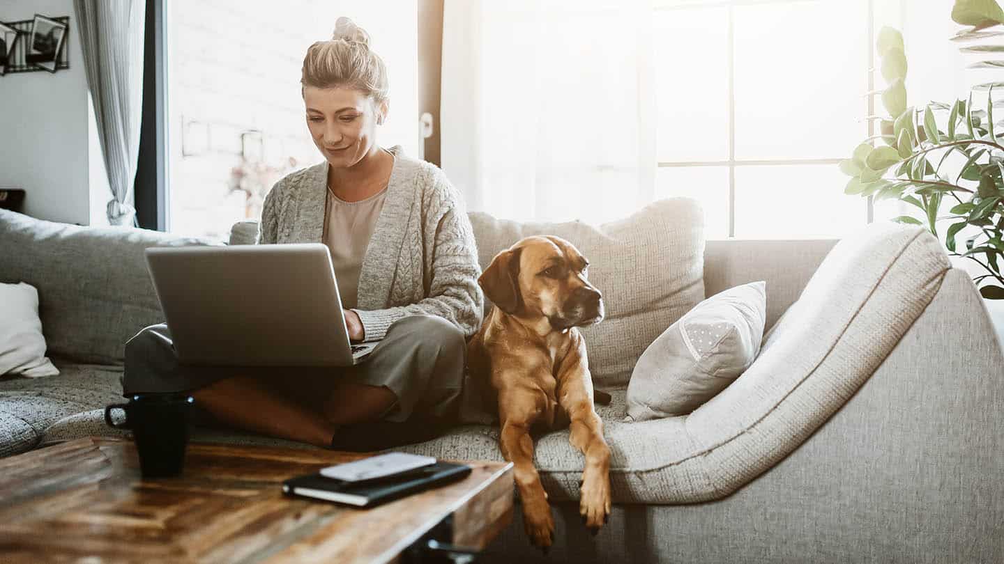 Businesswoman working on laptop computer sitting at home with a dog pet and managing her business via home office during Coronavirus or Covid-19 quarantine reviews Hero 1440x810 1