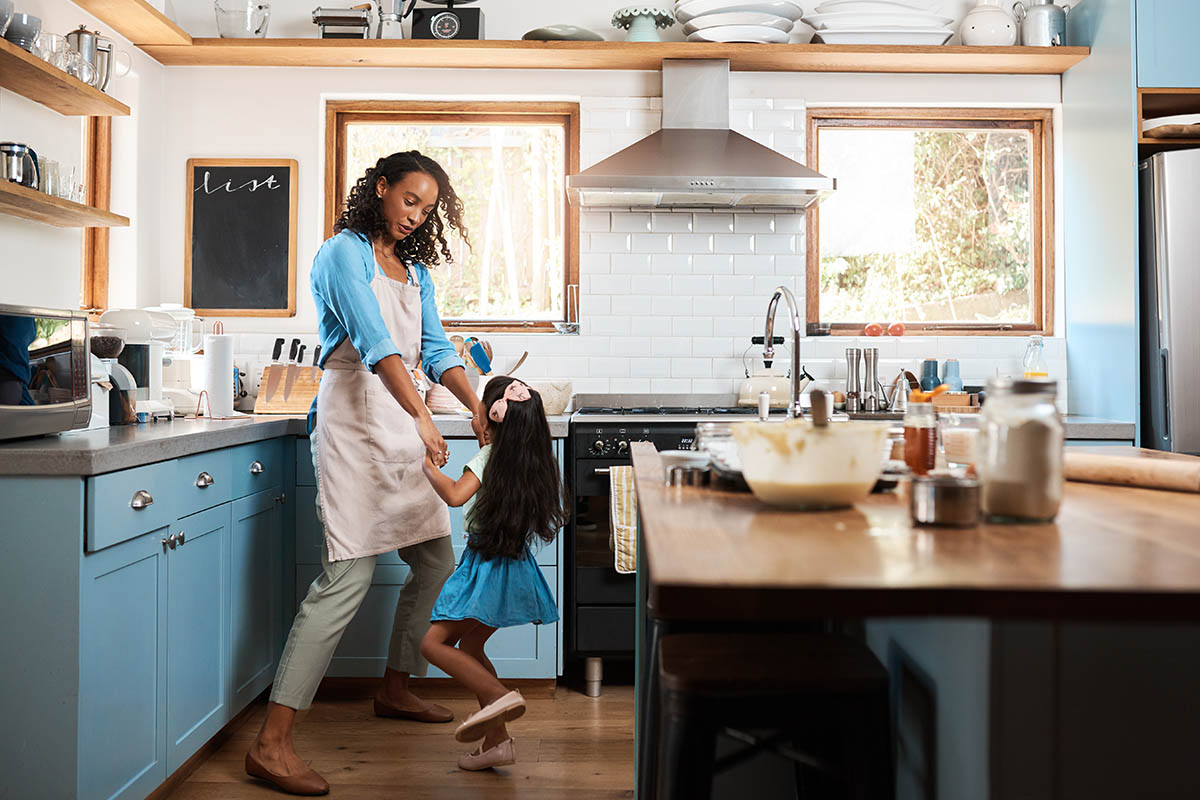 Having a good time in the kitchen Shot of a young woman dancing with her daughter in the kitchen at home