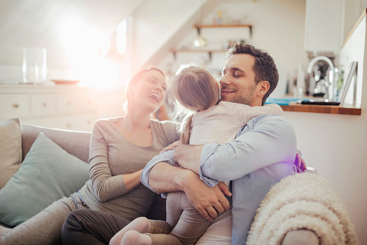 Happy young family relaxing on the couch at home Happy young family relaxing on the couch at home