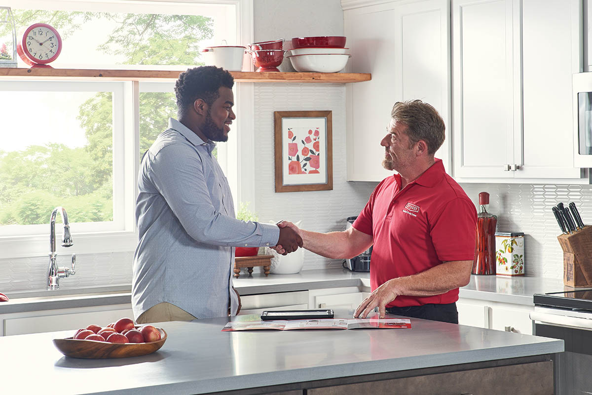 HVAC technician shaking hands with homeowner